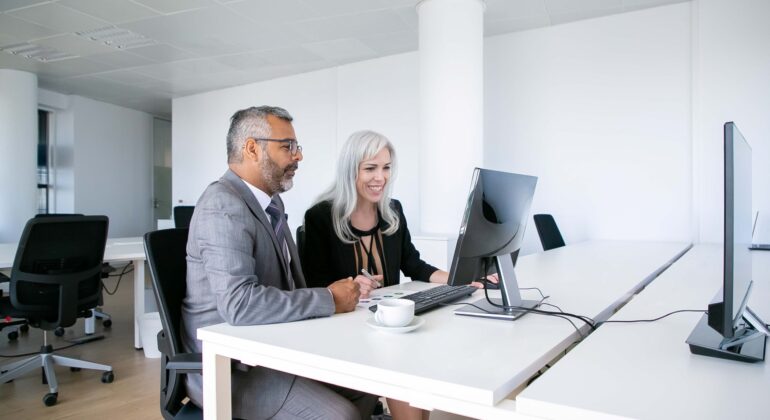 1. couple-cheerful-business-colleagues-watching-content-computer-monitor-smiling-laughing-while-sitting-workplace-business-communication-concept